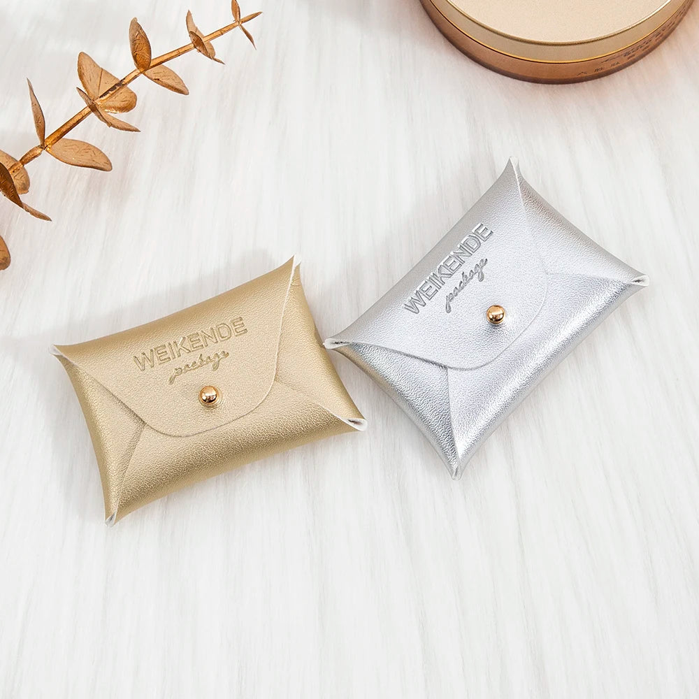 100 Stück Silberne Schmuckbeutel mit Logo – 10x7cm Lederbeutel mit Kordelzug | Für Ohrringe, Ringe, Halsketten, Münzen & Schlüsselanhänger Kaufschwan®