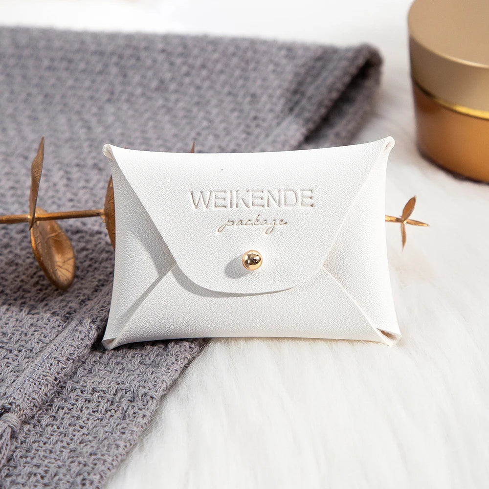 100 Stück Silberne Schmuckbeutel mit Logo – 10x7cm Lederbeutel mit Kordelzug | Für Ohrringe, Ringe, Halsketten, Münzen & Schlüsselanhänger Kaufschwan® Weiß 10x7cm